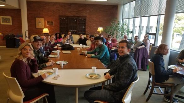 Students eating around a conference table